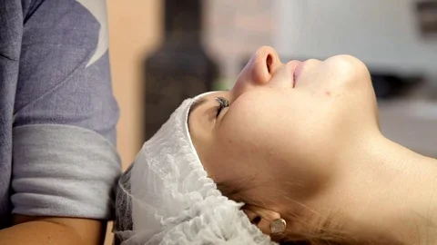 The make-up artist prepares the client for eyelash extensions, removing old Stock Footage