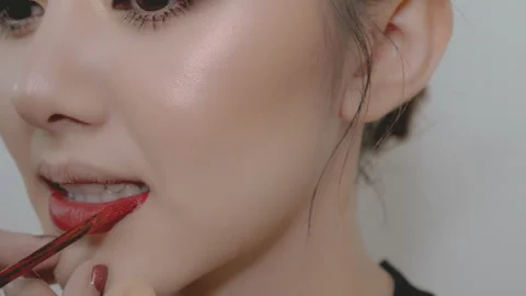 Make up artist put red lipstick to fashion model before catwalk Stock Footage 265863422
