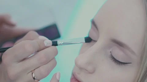 Make-up artist puts a brush for makeup to the eye model Video stock 68383879