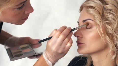 Make-up artist puts eye shadow in the beauty salon Video stock 78858426