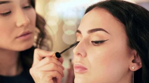 Make up artist puts mascara on model's eyelashes 動画素材 76086030