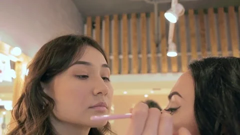 Make up artist puts mascara on model's eyelashes Stock Footage 76086241