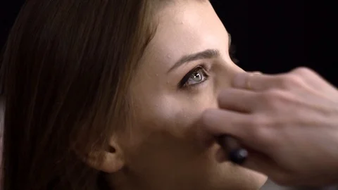 Make-up artist puts powder on face, model smiles close-up Vídeo Stock 85757747