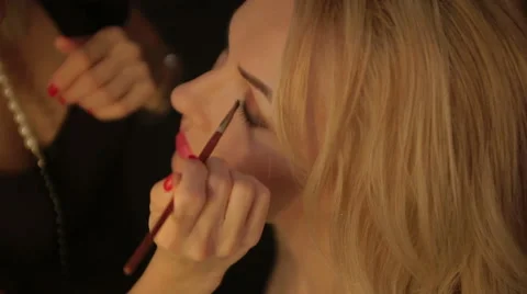 Make-up artist putting on make-up on model's eyes. Eye make-up Stock Footage 50979239