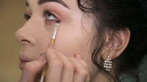 Make-up artist putting on makeup on model's eyes. Stock Footage