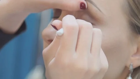 Make up artist putting on mascara on model's eyes. Eye make up Vídeos de archivo 69924331