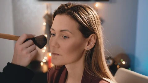 Make-up artist shading powder and a large brush makeup on the face of a Video stock 101455677
