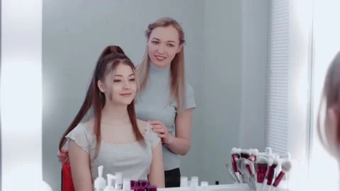 Make-up artist-stylist and model look in the mirror, smiling, Stock Footage 149686727