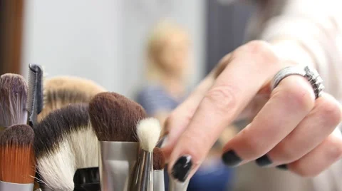 A make up artist taking a brush and gives a woman a new look Vidéo 63611950