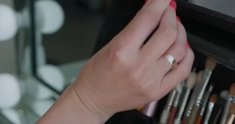 Make-up artist taking a brush from professional brush set. Beauty, makeup and Video stock 323241963