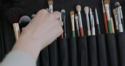 Make-up artist taking a brush from professional brush set. Beauty, makeup and Video stock 324819741