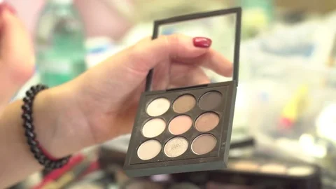 Make-up artist taking eye shadows from multicolor make-up eyeshadows palette in Stock Footage 71935605