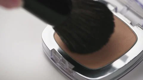 A make-up artist uses a black makeup brush and compact face powder in a case Stock Footage