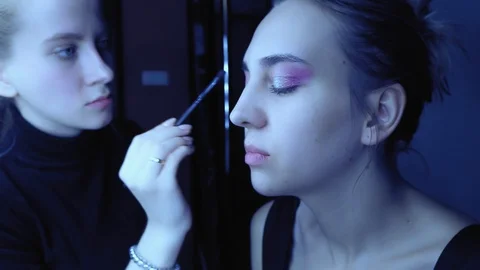 Make up artist uses make up on beautiful woman. Slowly camera leaves Stock Footage 85571427