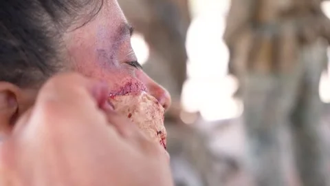 Make up artist using latex to create simulated wounds to soldiers face Stock Footage 280470173