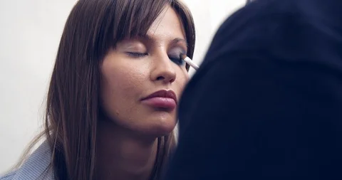 Make-up Artist at work.Eye make-up. Make-up artist putting on make-up on model's Stock Footage 126356520