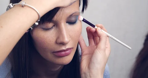 Make-up Artist at work.Eye make-up. Make-up artist putting on make-up on model's Stock Footage 126356563