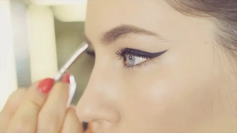 Make up artist works with a model at studio Stock Footage 84590364