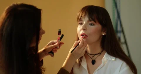 A make-up artist's hand applies a tone to the skin with a brush. Stock Footage 279916134