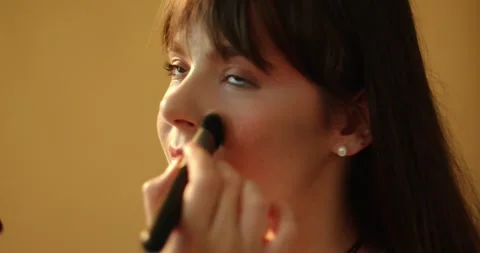 A make-up artist's hand applies a tone to the skin with a brush.  Stock Footage 279916186