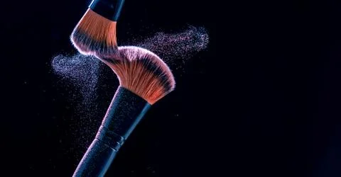 Make up brush with  powder explosion on black background Stock Photos