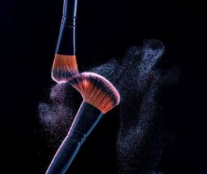 Make up brush with  powder explosion on black background Stock Photos