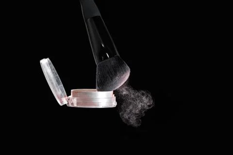 Make up brush with powder splashes on black background Photos