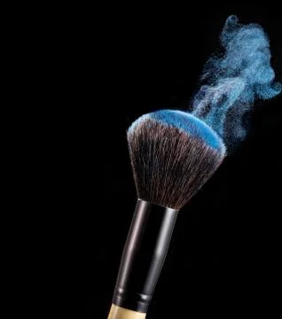 Make up brush with powder splashes on black background Фото