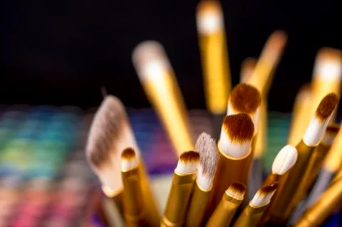 Make-up brushes in front of makeup palettes Stock Photos