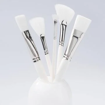 Make up brushes in a glass shot Make up brushes of different size and type... Stock Photos