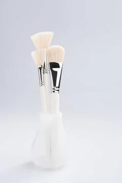 Make up brushes in a glass view Make up brushes of different size and type... Stock Photos