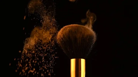 Make-up brushes with gold powder explosion on black background. Creative makeup Stock Footage 121356300