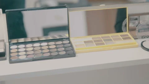 Make-up brushes laying on colorful cosmetic palette. Camera rotation Stock Footage 90603489