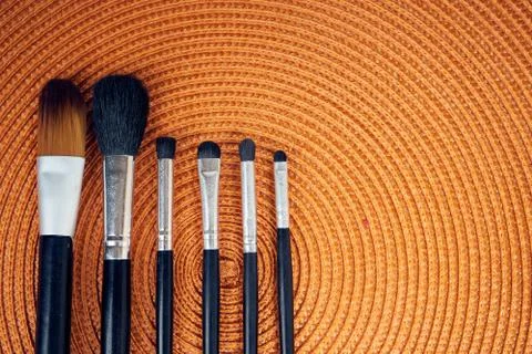 Make-up brushes on orange background Stock Photos