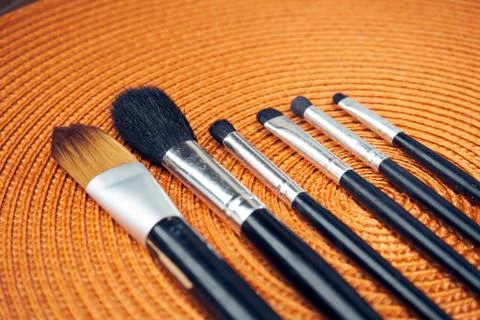 Make-up brushes on orange background Stock Photos