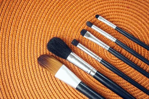 Make-up brushes on orange background Stock Photos