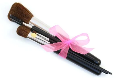 Make-up brushes with pink bow isolated over white Stock-Fotos