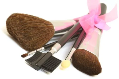 Make-up brushes with pink bow isolated over white Stock-Fotos