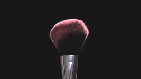 Make-up brushes with pink powder on a black background in slow motion Stock Footage 92118943