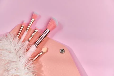 Make up brushes spilling out of a beige cosmetics bag Stock Photos