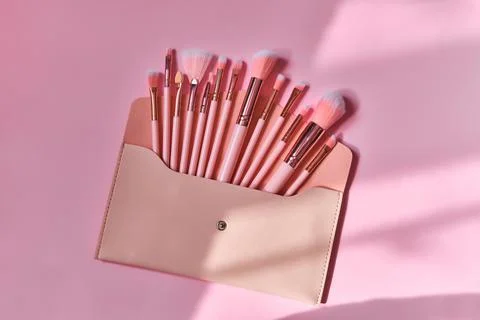 Make up brushes spilling out of a beige cosmetics bag Stock Photos