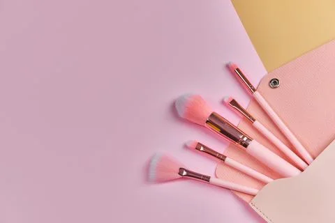 Make up brushes spilling out of a beige cosmetics bag Stock Photos