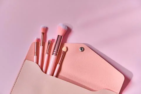 Make up brushes spilling out of a beige cosmetics bag Stock Photos