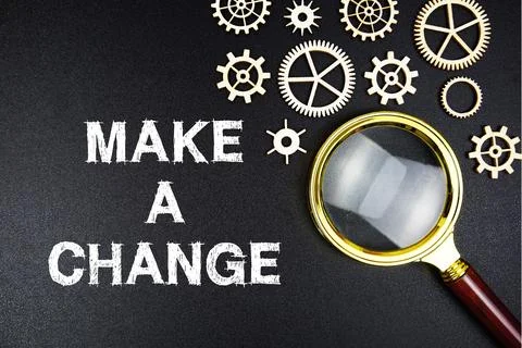 Make A Change text message with magnifying glass on black background Stock Photos