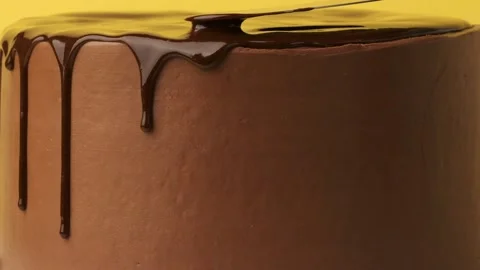 Make chocolate drips on the brown cream cheese frosted cake Stock Footage 237332142