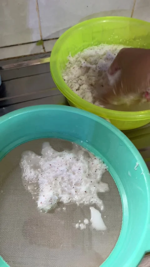 Make coconut milk by squeezing grated coconut in the traditional way Stock Footage 296454310