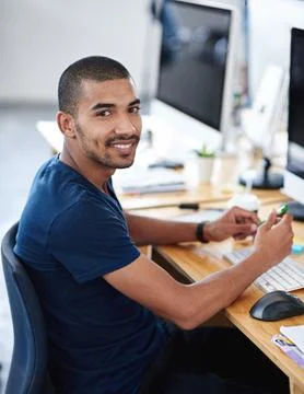 Make creativity a job. Portrait of a young designer at work on his computer. Stock Photos