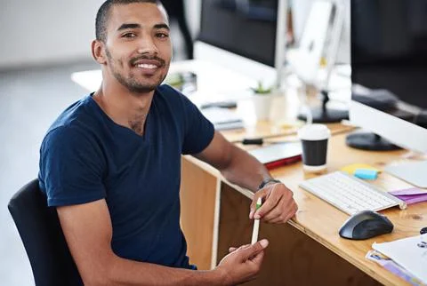 Make creativity a job. Portrait of a young designer at work on his computer. Stock Photos