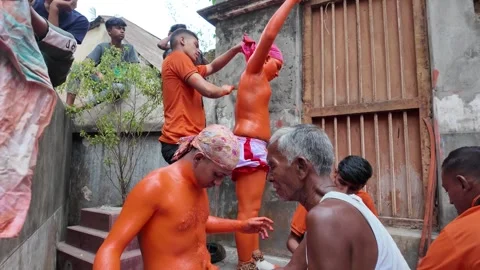 Make up of a devotee covered with orange at Lal Kach, Munshiganj, Bangladesh Stock Footage 310751720
