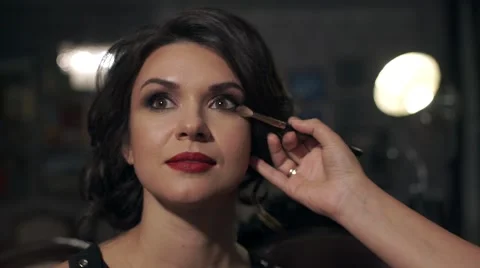 Make-up does make-up on her eyes beautiful bright girl with red lips on the Stock Footage 68928564